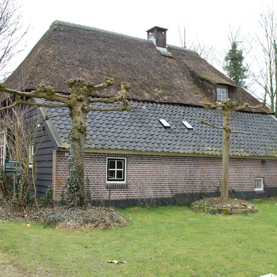 Goed bewaarde boerderij onder hoog, rieten wolfdak