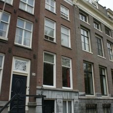 Pand met gevel onder rechte lijst met geblokte onderpui