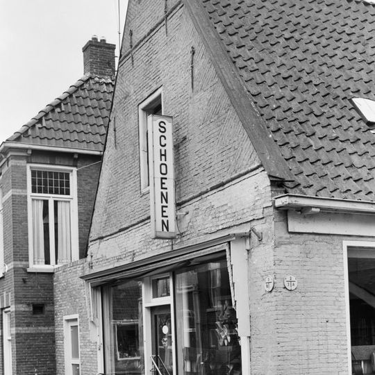 Pand onder zadeldak tussen puntgevels met vlechtingen en sierankers