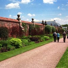 Walls with pair of gates and overthrow, central, along southern boundary of walled garden