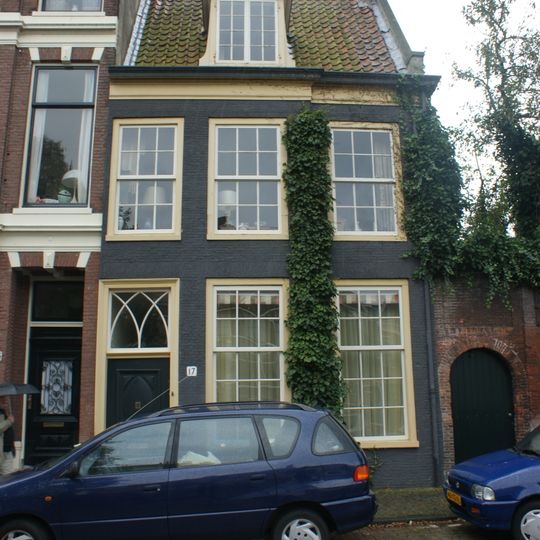 Pand met rechte kroonlijst, vroeger breder, zadeldak in topgevel terzijde eindigend, gevel met dodekop geverfd