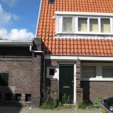 Blok met 8 keukenwoningen, zo genoemd vanwege destijds nieuwe plaatsing van keuken aan de voorzijde, aan de zijkant een houten topgevel, bouwstijl Amsterdamse School.