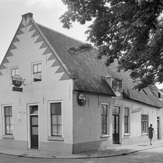 Het Oude Rechthuis: gepleisterd pand met puntgevel, waarin vlechtingen en ontlastingsbogen. Zadeldak, met riet gedekt