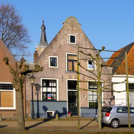 Huis met puntgevel met halfrond afgedekte top