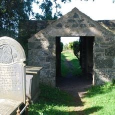 Lychgate and churchyard wall to Church of St Tudwen