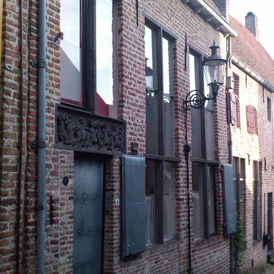 Huis met gepleisterde gevel onder dwars zadeldak tussen twee topgevels