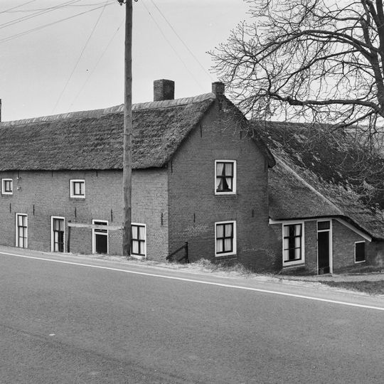 Boerderij met woongedeelte onder rieten zadeldak evenwijdig aan de weg