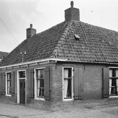 Woning met zesruitsvensters onder schilddak met hoekschoorstenen