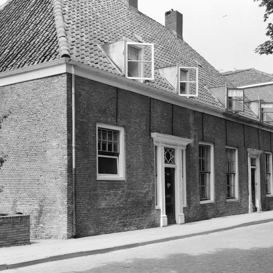 Voormalig rechthuis. Huis van begane grond onder een hoog schilddak met de nrs 32-34-36. IJsselstenen gevel met rode strekken boven de vensters.