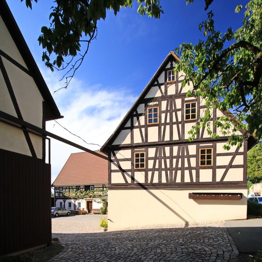 Wohnstallhaus , Seitengebäude und Scheune eines Vierseithofes Hauptstraße 10