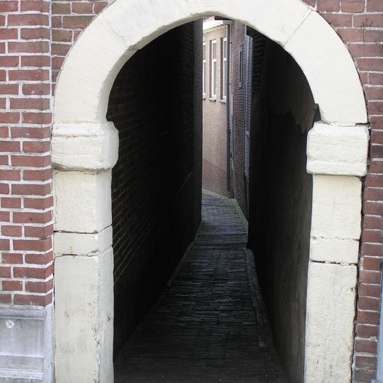 Hardstenen poortomlijsting, toegang tot het Vuilstraatje. Een gans op de gebeeldhouwde sluitsteen