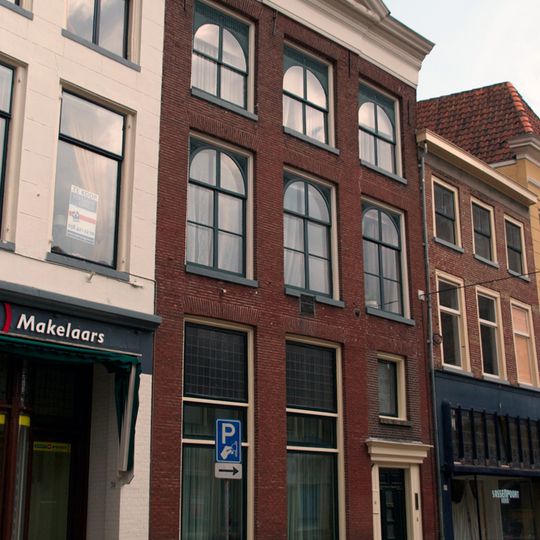 Pand met kroonlijst, fronton, halfrond beëindigde empire-ramen met snijwerk op de verdieping en festoenen in de sokkel op de beganegrond