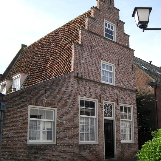 Pand onder zadeldak tegen gepleisterde trapgevel