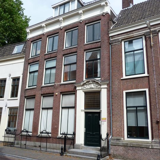 Pand met gevel met rechte consoles kroonlijst, versierde deurpartij, gesmeed ijzeren hek