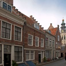 Huis met in geel en rood gemetselde langsgevel op natuurstenen plint
