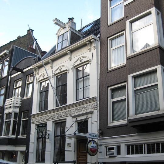 Huis met gepleisterde en van stucversiering voorziene gevel
