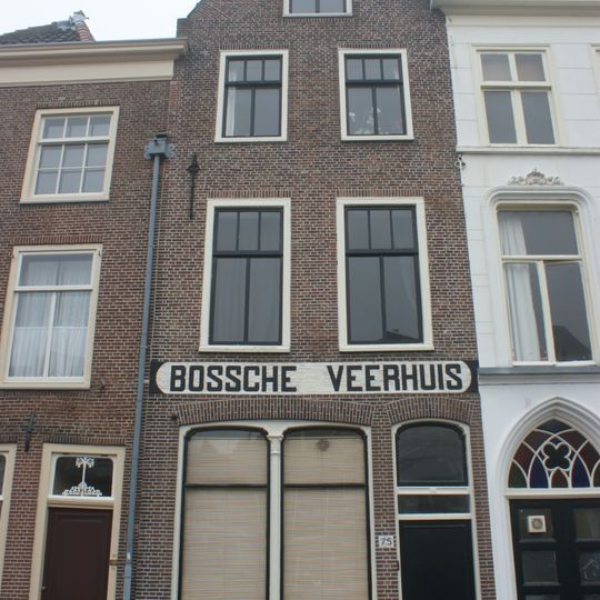 Pand met puntgevel met eenvoudige siersmeedankers. Onderpui verbouwd