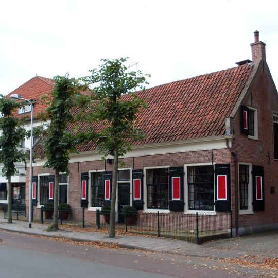 Lage woning, gevel met rechte kroonlijst, in topgevels eindigend tentdak, roedenverdeling vensters