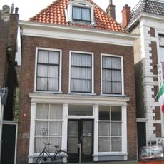 Pand met strakke gevel bekroond door rechte gootlijst en dakkapel in 18e-eeuwse vormen