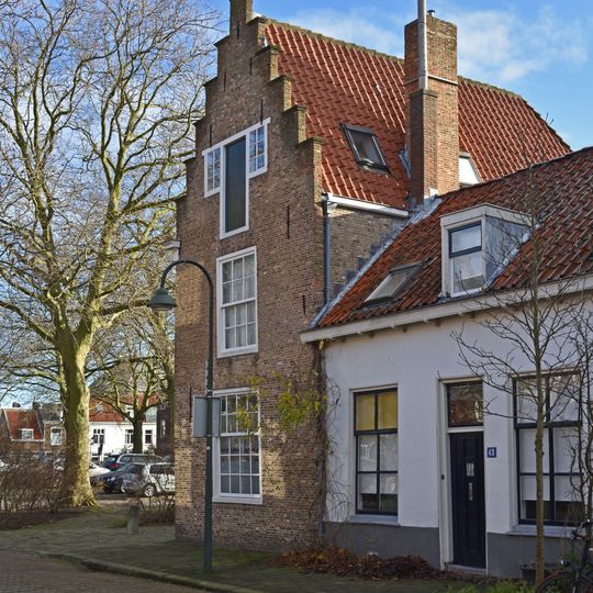 Hoekpand Paardenmarkt, huis onder hoog schilddak, dat met de lange zijde aan de Paardenmarkt ligt en aan de voorzijde een gepleisterde trapgevel
