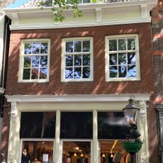 Pand onder zadeldak met in voorgevel gootlijst met consoles en topgevel aan de achterzijde