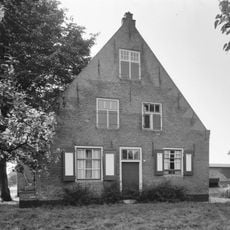 Huis met tuitgevel met vlechtingen