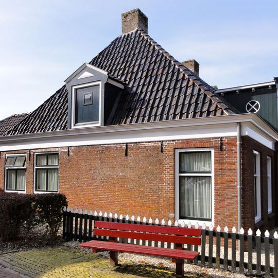 Pand met vernieuwde voor- en zijgevels onder schilddak met dakkapel en hoekschoorstenen