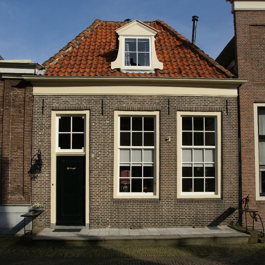 Eenvoudig laag pand met schilddak, vensters met roeden, marmeren stoep