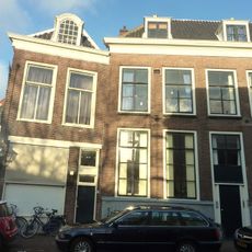 Pand onder zadeldak. Kroonlijst met in het fries panelen en gesneden Lodewijk XIV-consoles