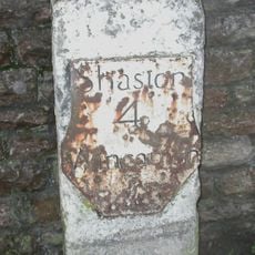 Milestone, by railway bridge