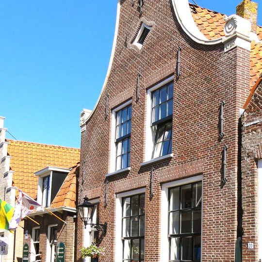 Pand onder zadeldak tussen puntgevels met nieuwe voorgevel en achtergevel met twee friezen