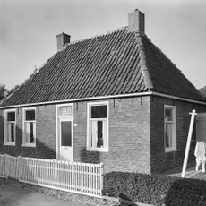 Eenvoudig pand onder schilddak met hoekschoorstenen