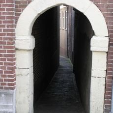 Hardstenen poortomlijsting, toegang tot het Vuilstraatje. Een gans op de gebeeldhouwde sluitsteen