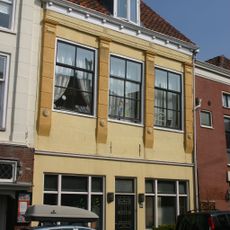 Pand met gepleisterde pilastergevel. Moderne onderpui