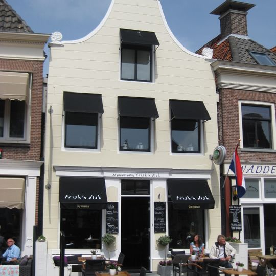 Pand onder zadeldak met gepleisterde gevel met klokvormige beëindiging en aanzetkrullen