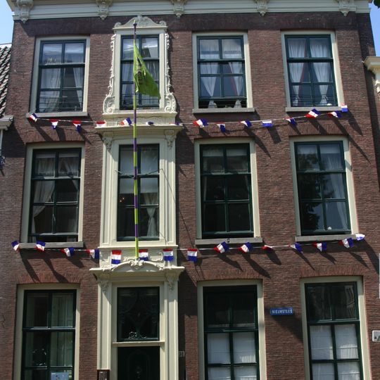 Pand met brede baksteen gevel met rechte console kroonlijst. Lod. XV omlijsting deurpartij, gesneden voordeur. Dak van latere datum