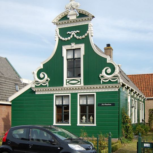 Houten huis met rijk versierd voorschot in Lodewijk XVI-stijl