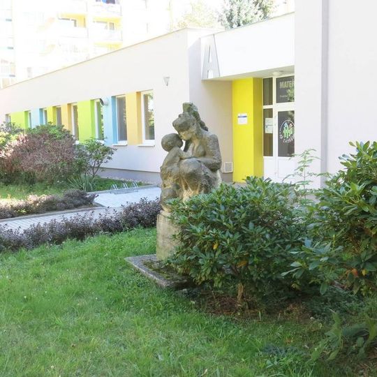 Socha Mateřství před školkou Pražská 2812 ve Varhsdorfu