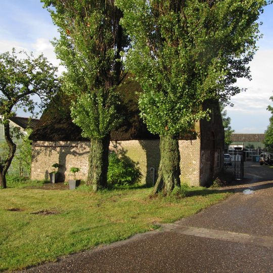 Boerderij op het erf van nr 11, thans als schuur gebruikt, met rieten zadeldak.