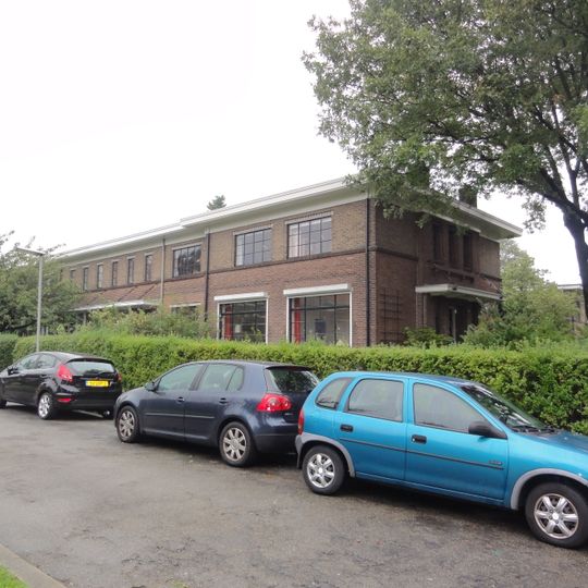 Vier woningen met poort en schuurtjes