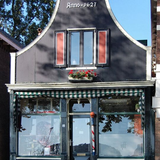 Houten huis met ingezwenkt voorschot, bekroond door een fronton