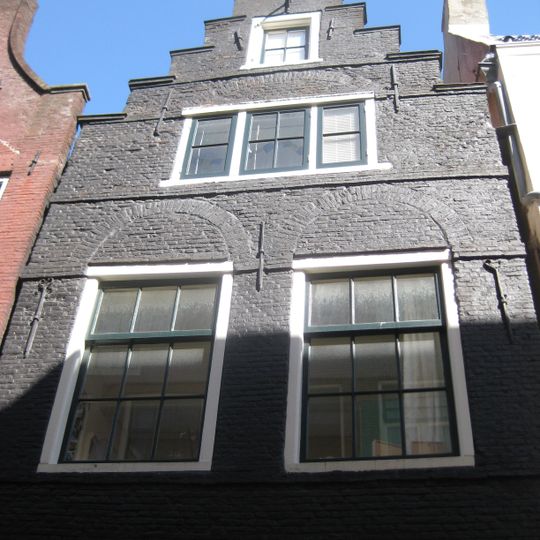 Pand met trapgevel verwant aan het 'type-met-kleine-blokjes', doch geheel in baksteen uitgevoerd